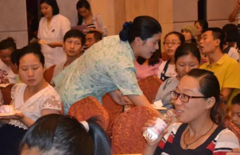 城阳玛丽手术室吴护士长将三周年蛋糕递给准妈妈